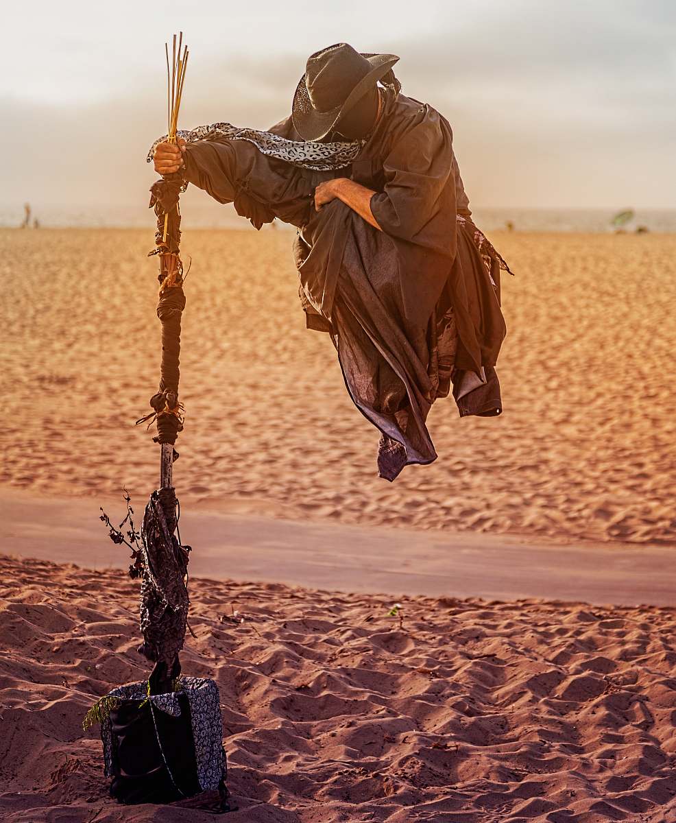 los angeles person in overall suit holding rod floating on desert field united states
